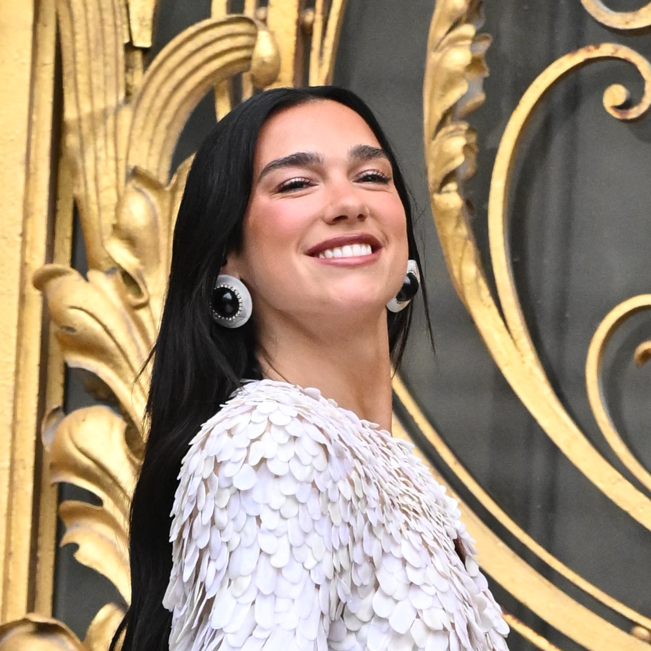 a woman with long black hair in a textured jacket