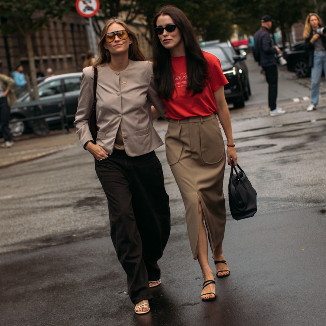 two Copenhagen fashion week attendees crossing the straight with their arms over each other 